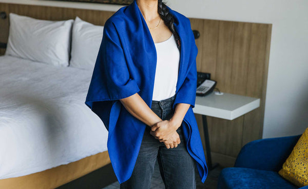 A Large Shepherd's Wool Utility Cloth in Neela Blue being worn by a person as a shawl.